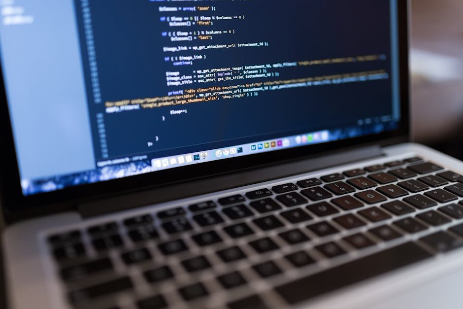 Photograph of a computer screen displaying HTML code in an IDE, with visible code lines including tags such as <!DOCTYPE html>, <html>, <head>, and <body>. The code features syntax highlighting with d